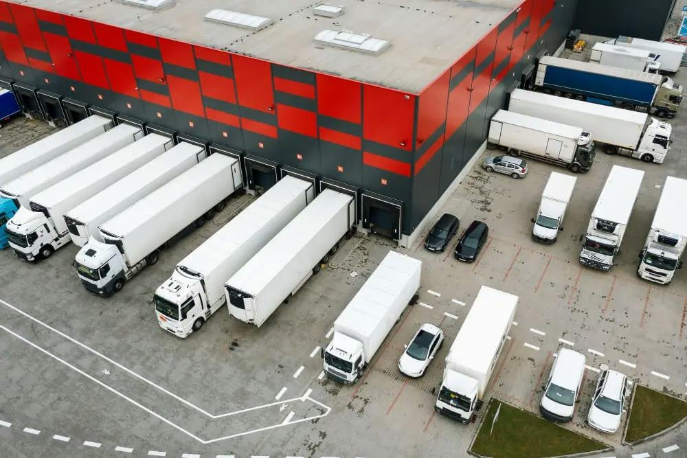 Logistyka dystrybucji – magazyn oraz samochody ciężarowe widziane z lotu ptaka
